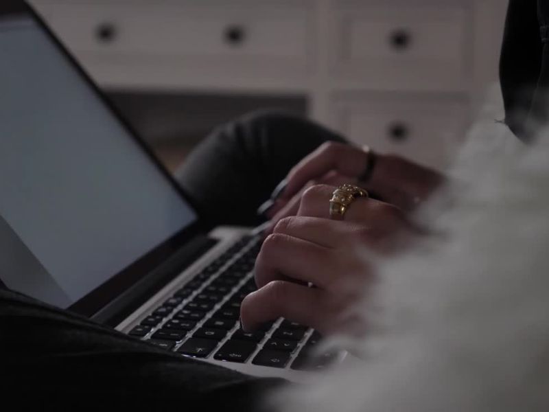devojka sa prstenjem na ruci pretražuje po internetu, koristeći laptop