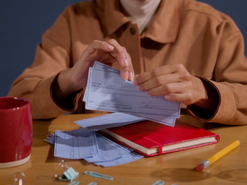 osoba drži par potpisanih čekova u ruci