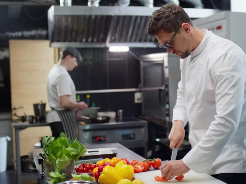 dva radnika rade u kuhinji u restoranu