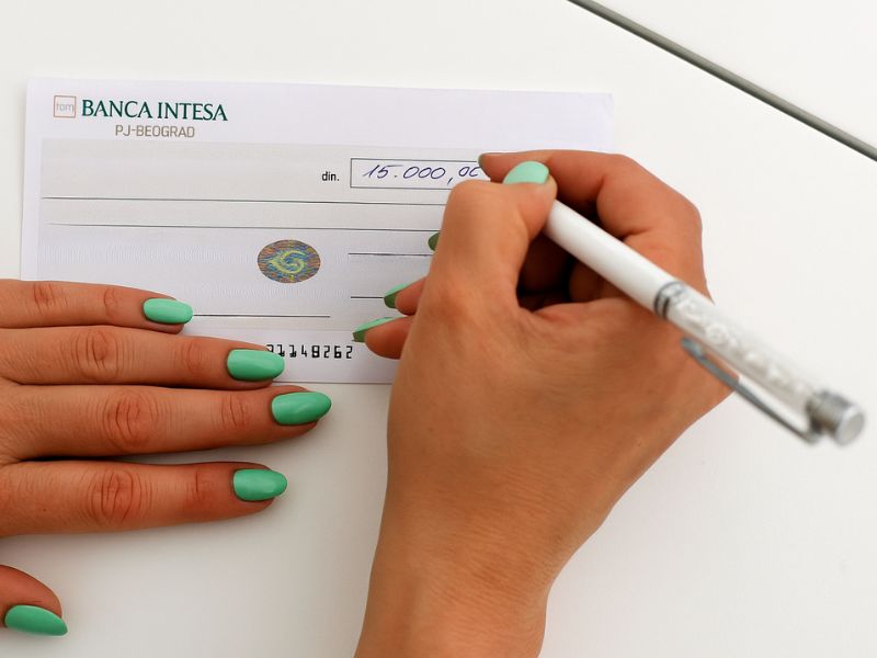 osoba popunjava ček