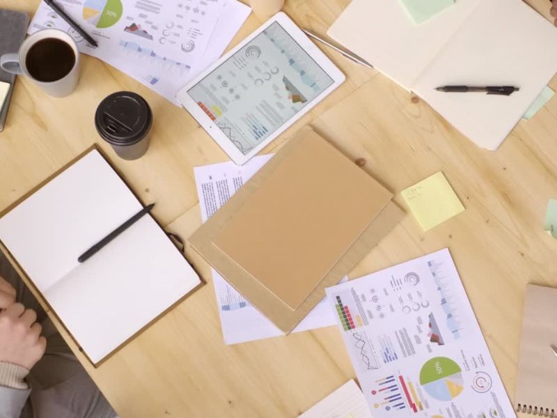 prikaz kancelarijskog stola sa dokumentima, kafom i notesima