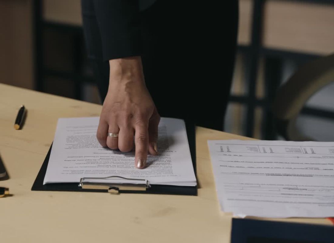 osoba čita dokument koji stoji na stolu