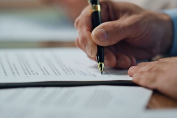 osoba potpisuje papir