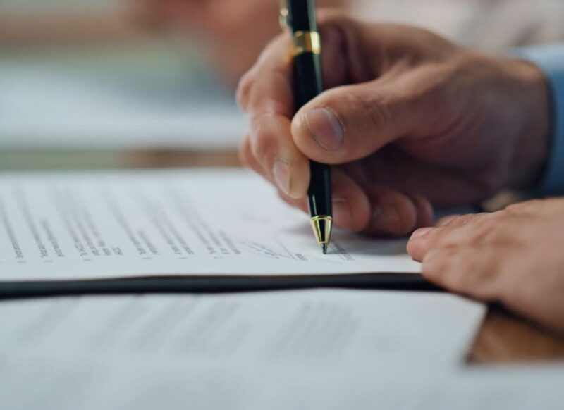 osoba potpisuje papir