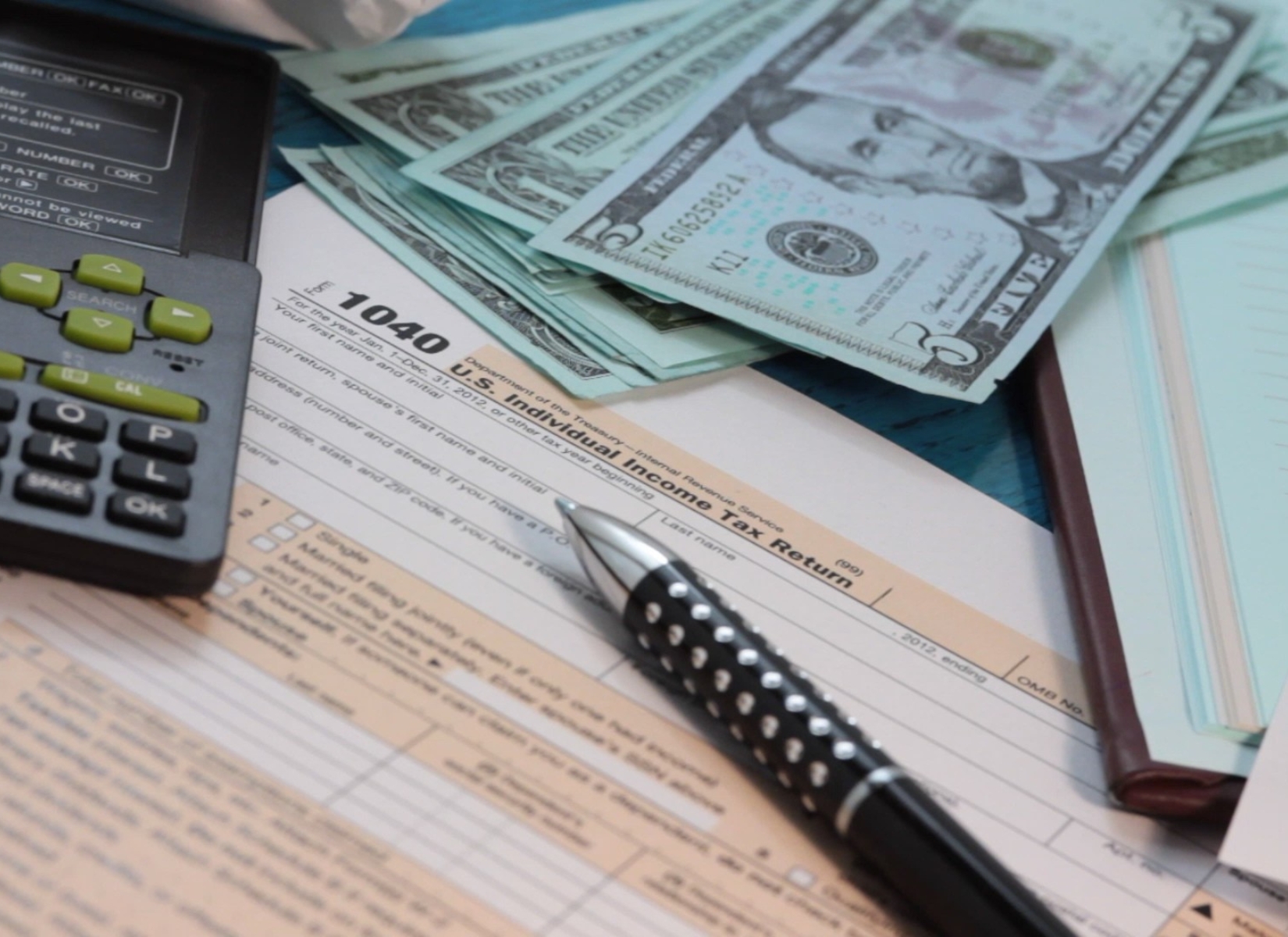 prikaz papira za bolovanje, novca i kalkulatora