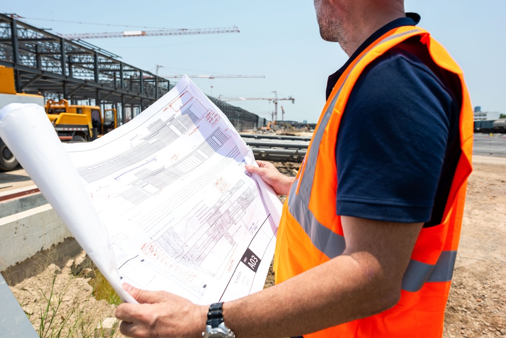 Inženjer na gradilištu proverava tehničku dokumentaciju i planove projekta