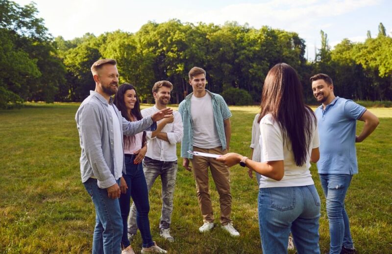 Grupa ljudi na tim bildingu na poljani dogovaraju igre