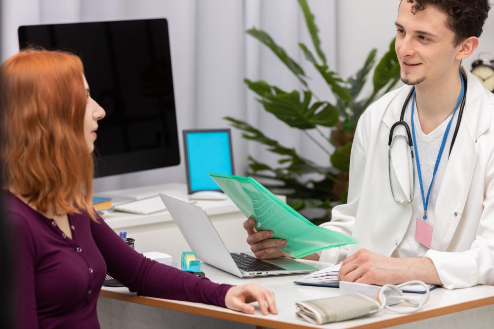 Lekar razgovara sa pacijentkinjom i pregleda medicinsku dokumentaciju u ordinaciji.